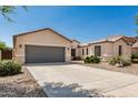 Single-story home with a large driveway leading to a spacious two-car garage, complemented by low maintenance front yard at 4520 N 151St Dr, Goodyear, AZ 85395