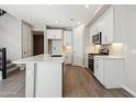 Modern kitchen features white cabinets, stainless steel appliances, and a center island with stone countertops at 5815 E Covey Ln, Phoenix, AZ 85054