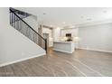 Open floor plan featuring tile floors, kitchen with island, and a staircase with iron railing to the second floor at 5815 E Covey Ln, Phoenix, AZ 85054