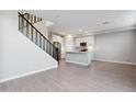 Open-concept living space with modern staircase and bright kitchen featuring white cabinets and stainless steel appliances at 5831 E Covey Ln, Phoenix, AZ 85054