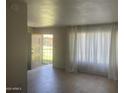 Bright living room featuring tile flooring and large window with light filtering curtains at 6029 N 31St Ave, Phoenix, AZ 85017