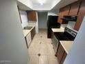 Cozy kitchen featuring tile flooring, ample cabinet space, and modern black appliances at 6911 W Devonshire Ave # 1269, Phoenix, AZ 85033