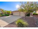 Single-story home showcasing a three-car garage, desert landscape and well-kept curb appeal at 8402 W Rosemonte Dr, Peoria, AZ 85382