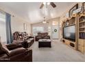 Cozy living area featuring leather furniture, vaulted ceiling, and a decorative entertainment center at 8622 W Shaw Butte Dr, Peoria, AZ 85345