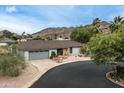 Aerial view of a charming single-story home with a two-car garage and picturesque mountain views at 9039 N Concho Ln, Phoenix, AZ 85028