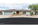 Inviting single-story home featuring a stone facade, xeriscaping, and a two-car garage at 9039 N Concho Ln, Phoenix, AZ 85028
