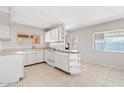 Cozy kitchen with white cabinets, a breakfast bar, and tile flooring, perfect for casual dining at 12201 N 22Nd Pl, Phoenix, AZ 85022