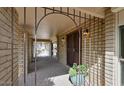 Welcoming covered entrance with brick accents, a secure iron gate, and a charming potted plant, enhancing curb appeal at 13019 N 23Rd Pl, Phoenix, AZ 85022