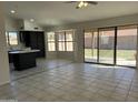 Open-concept living space with tile floors, large windows, and sliding glass doors to backyard at 15801 W Meade Ln, Goodyear, AZ 85338
