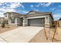 Charming single-story home with gray stucco, stone accents, a two-car garage, and low maintenance landscaping at 17773 W Onyx Ave, Waddell, AZ 85355