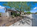 A view of the front yard with desert landscaping, a home with shutters, and a neighborhood street at 17966 W Agave Rd, Goodyear, AZ 85338