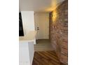 Inviting entryway with brick accent wall, light fixture, and durable tile and wood floors at 1800 W Elliot Rd # 107, Chandler, AZ 85224
