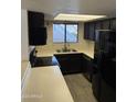 Well-lit kitchen featuring sleek black appliances, white countertops, and stylish tiled backsplash at 1800 W Elliot Rd # 107, Chandler, AZ 85224