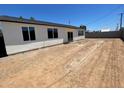 Expansive backyard featuring multiple windows providing ample natural light and block fence, perfect for outdoor activities at 1835 E Burgess Ln, Phoenix, AZ 85042