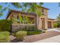 Beautiful single-Gathering home featuring a two-car garage, stone accents, and lush desert landscaping at 20499 W Alsap Rd, Buckeye, AZ 85396