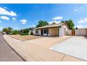 Street view of a single-story home with low maintenance desert rock landscaping and a spacious driveway at 2215 W Straford Dr, Chandler, AZ 85224