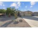 Attractive single-story home with a three-car garage, desert landscaping, and stone accents at 2830 S Riata Ct, Gilbert, AZ 85295