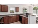 Kitchen featuring wood cabinetry, stainless steel sink, and views to the backyard at 336 N 168Th Dr, Goodyear, AZ 85338