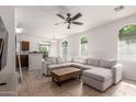Bright living room with arched windows, a ceiling fan, and tile flooring throughout at 336 N 168Th Dr, Goodyear, AZ 85338