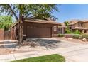 Attached two-car garage showing a concrete driveway, a tree in the yard, and easy access to the home at 3480 E Cullumber Ct, Gilbert, AZ 85234