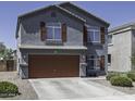 Two-story home featuring a gray stucco exterior and a two-car garage at 36562 W Nina St, Maricopa, AZ 85138