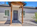 Inviting front entrance featuring a gray door, wooden support beams, and a paved walkway, enhancing curb appeal at 3831 N 8Th St, Phoenix, AZ 85014