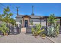 Attractive single-story home with desert landscaping, a dark wooden fence, and a covered entrance, adding character at 3831 N 8Th St, Phoenix, AZ 85014
