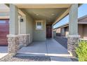 Inviting covered porch with stone accents creating curb appeal at 40060 W Wade Dr, Maricopa, AZ 85138