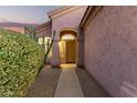Charming front entrance with an arched doorway, desert foliage, and a well-lit pathway to the front door at 689 E Stottler Dr, Gilbert, AZ 85296