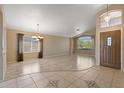 Spacious living room with tile flooring, a chandelier, large windows, and a view of the front yard at 10936 N Ventana W Dr, Peoria, AZ 85373