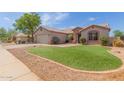 Single story home boasting low maintenance landscaping, desert rock, and a pop of green grass at 1642 E Desert Ln, Phoenix, AZ 85042