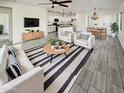 Bright and airy living room featuring modern decor, tile floors, and an open floor plan leading into the kitchen at 19904 W Sherman St, Buckeye, AZ 85326