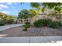Charming two-story beige home featuring landscaped front yard with green trees and decorative rocks at 22193 E Via Del Oro --, Queen Creek, AZ 85142