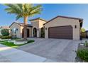 Single Gathering home featuring a three car garage, brick driveway and desert landscaping with a palm tree at 30404 N 131St Dr, Peoria, AZ 85383