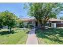 Charming home with a welcoming walkway, mature trees, and well-maintained landscaping creating great curb appeal at 325 W Loma Ln, Phoenix, AZ 85021