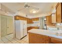 Well-lit kitchen with oak cabinets, white appliances, and classic tile creating a bright and inviting cooking space at 325 W Loma Ln, Phoenix, AZ 85021