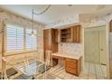 Cozy breakfast nook with a glass table, wooden cabinets, and a sunny window with plantation shutters at 325 W Loma Ln, Phoenix, AZ 85021