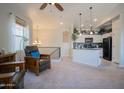 Open-concept living area with a view of the kitchen, featuring natural light, furniture, and neutral decor at 34979 N 30Th Ave, Phoenix, AZ 85086