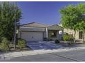 Inviting front exterior featuring a well-manicured lawn, mature trees, and a two-car garage at 37390 W Merced St, Maricopa, AZ 85138