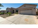 A well-maintained single-story home features a spacious driveway and desert landscaping under a blue sky at 4229 E Nightingale Ln, Gilbert, AZ 85298
