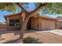Lovely single-story home with desert landscaping, a shade tree, and a two-car garage at 4817 W St Charles Ave, Laveen, AZ 85339