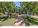 Inviting home with a tile walkway, mature trees, a well-maintained lawn, and beautiful landscaping at 530 W Willetta St, Phoenix, AZ 85003