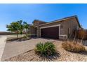 Single-story home with a two-car garage, stone accents, and low-maintenance desert landscaping at 7620 W Pioneer St, Phoenix, AZ 85043