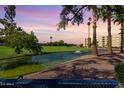Beautiful view of the community featuring lush greenery, a serene pond, and palm trees at 7970 E Camelback Rd # 101, Scottsdale, AZ 85251