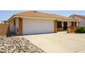 Single story home featuring a two car garage, desert landscaping, and a charming entrance with brick accents at 8230 E Navarro Ave, Mesa, AZ 85209
