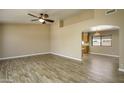 Spacious living room with wood-style tile flooring, neutral paint, abundant natural light, and an open floor plan at 8230 E Navarro Ave, Mesa, AZ 85209