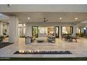 Inviting covered patio with a fire feature and seamless transition to the living and kitchen areas at 9441 N 129Th Pl, Scottsdale, AZ 85259