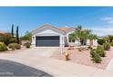 Home exterior showcasing desert landscaping, a gray garage door, and a terracotta tile roof at 9791 N 118Th Way, Scottsdale, AZ 85259