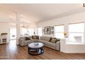 Spacious living room featuring wood floors, a large sectional sofa and plenty of natural light at 9791 N 118Th Way, Scottsdale, AZ 85259