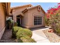 Exterior view of a home with desert landscaping featuring mature bushes and a walkway leading to the front door at 10931 N 129Th Way, Scottsdale, AZ 85259